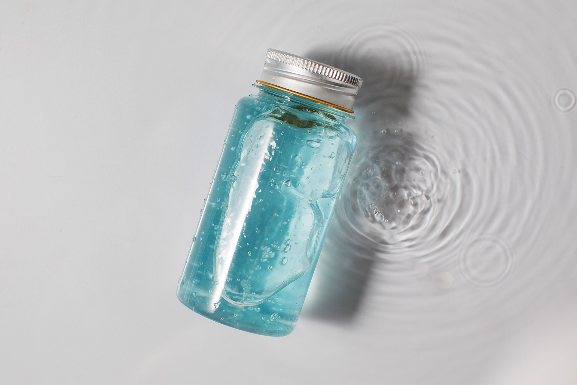 bottle-of-blue-gel-skincare-product-on-white-water-2022-01-26-16-15-55-utc.jpg